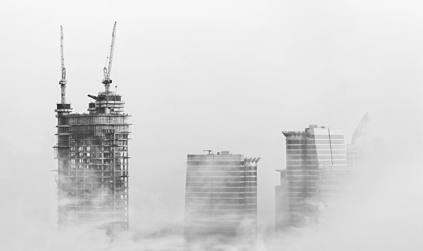 Construction cranes above the cloud line